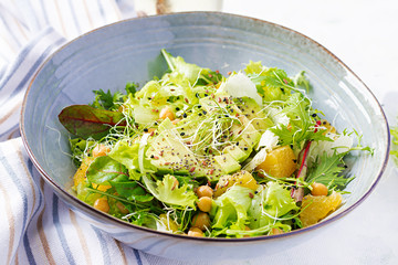 Vegetarian/ vegan salad with boiled chickpeas, greens, avocado, orange and chia seeds. Healthy eating trend, superfood.