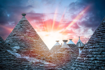 Panoramic view of ancient traditional  buildings called Trulli in Alberobello. Sunset between the...