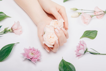 Fototapeta na wymiar Beautiful stylish trendy female pink manicure with flower on background, top view. Concept bio nature cosmetics skin care