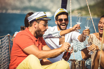 Smiling friends with glasses of champagne on yacht. Vacation, travel, sea, friendship and people...
