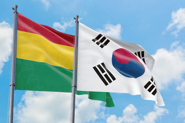 South Korea and Bolivia flags waving in the wind against white cloudy blue sky together. Diplomacy concept, international relations.