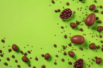 Egg hunt is coming. Easter traditions, chocolate eggs on green background, top view, copyspace for your ad or greetings. Concept of holidays, spring, celebrating, food and sweets, family time.