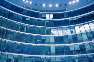 Fototapeta na wymiar Night architecture - building with glass facade. Abstract image of office building