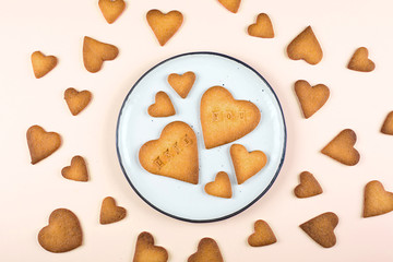 Plate with sweet cookies for Valentines day. Shortbread cookies in shape of heart. Top view, flat lay