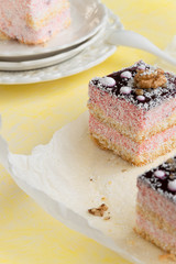 Delicious slices of cake with strawberry cream and coconut, yellow background, creamy dessert, holiday themes