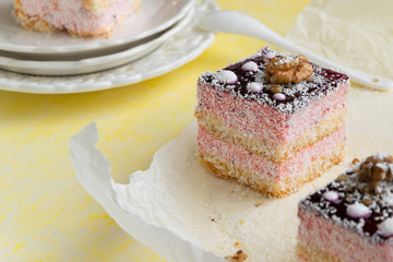 Delicious slices of cake with strawberry cream and coconut, yellow background, creamy dessert, holiday themes