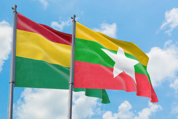 Myanmar and Bolivia flags waving in the wind against white cloudy blue sky together. Diplomacy concept, international relations.