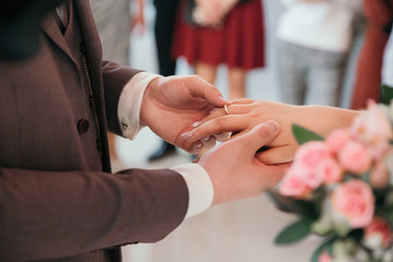 Obraz na płótnie Canvas close up. bride and groom exchanging their wedding rings.