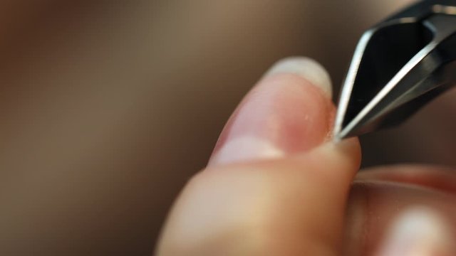 Careful removing of cuticle  with special cutter. A manicurist removes a cuticle from a client&rsquo;s nail. Manicure.