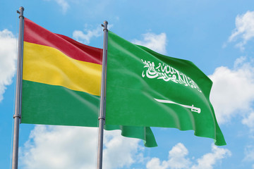 Saudi Arabia and Bolivia flags waving in the wind against white cloudy blue sky together. Diplomacy concept, international relations.