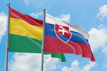 Slovakia and Bolivia flags waving in the wind against white cloudy blue sky together. Diplomacy concept, international relations.