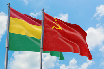 Soviet Union and Bolivia flags waving in the wind against white cloudy blue sky together. Diplomacy concept, international relations.