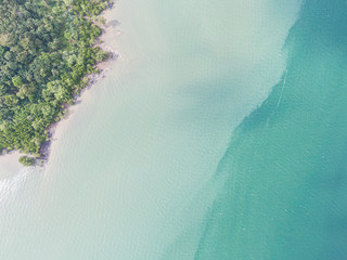 An aerial view of an asian beach with clear blue water and waves