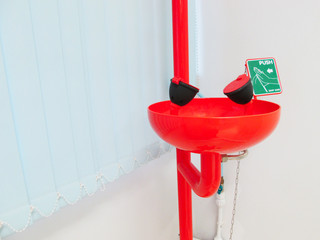 The eye wash station and push on the green button for flowing the water washing eyes, when touch with Acid or toxic chemical, safety first protection equipment in chemistry laboratory. Emergency Kit.