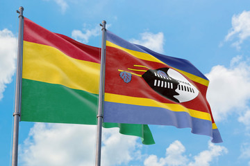 Swaziland and Bolivia flags waving in the wind against white cloudy blue sky together. Diplomacy concept, international relations.