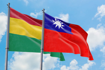 Taiwan and Bolivia flags waving in the wind against white cloudy blue sky together. Diplomacy concept, international relations.