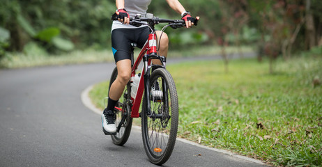 Fototapeta na wymiar Woman cyclist riding mountain bike in park