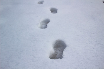 A steps against snow background. footprints on white snow background of boots. Human traces on snow.