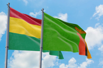 Zambia and Bolivia flags waving in the wind against white cloudy blue sky together. Diplomacy concept, international relations.