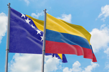 Colombia and Bosnia Herzegovina flags waving in the wind against white cloudy blue sky together. Diplomacy concept, international relations.