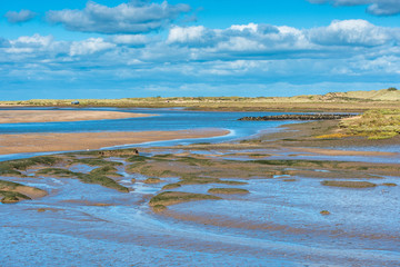 Views of mudflats at low tide from Norfolk Coast path National Trail near Burnham Overy Staithe, Scolt Head Island to rear, East Anglia, England, UK.