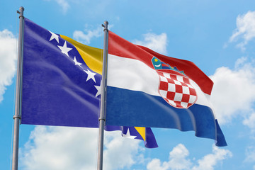 Croatia and Bosnia Herzegovina flags waving in the wind against white cloudy blue sky together. Diplomacy concept, international relations.