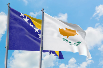 Cyprus and Bosnia Herzegovina flags waving in the wind against white cloudy blue sky together. Diplomacy concept, international relations.