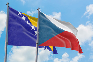 Czech Republic and Bosnia Herzegovina flags waving in the wind against white cloudy blue sky together. Diplomacy concept, international relations.