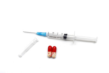 syringe with injection and two capsules on a white background.