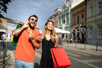 Beautiful young loving couple walking by the street while shopping and traveling