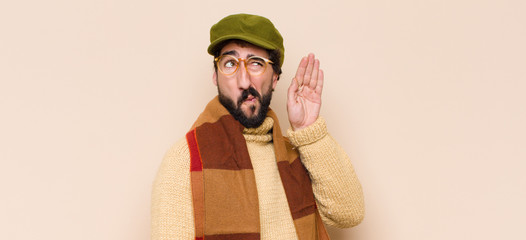 young cool bearded man looking serious and curious, listening, trying to hear a secret conversation...
