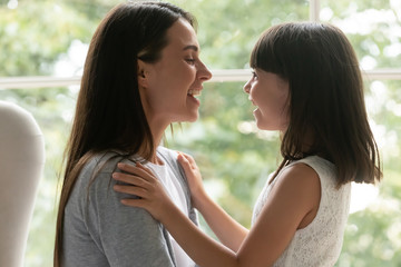 Overjoyed little daughter feel happy talking with mom