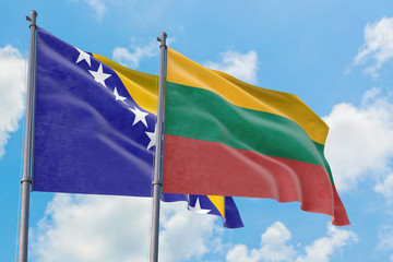 Lithuania and Bosnia Herzegovina flags waving in the wind against white cloudy blue sky together. Diplomacy concept, international relations.