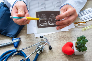Ultrasound examination in cardiology concept photo. Doctor during consultation held in his hand and...