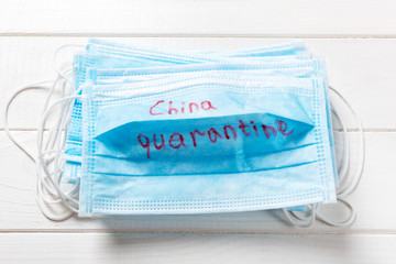 China quarantine word written on medical mask. text on protective mask for your desing, Wuhan Coronavirus, 2019-nCoV. concept top view