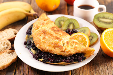 omelet with blueberry, fruit, orange juice, coffee cup and bread- healthy breakfast