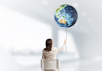 Woman holding by rope earth globe