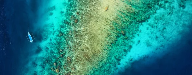 Zelfklevend Fotobehang Panoramisch zicht op het koraalrif en de boot. Azuurblauwe waterachtergrond van bovenaanzicht. Zomer zeegezicht vanuit de lucht. Reizen - afbeelding © biletskiyevgeniy.com