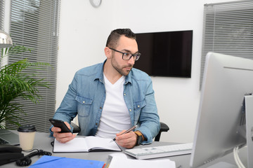 handsome young happy and successful businessman in casual wear at office business desk