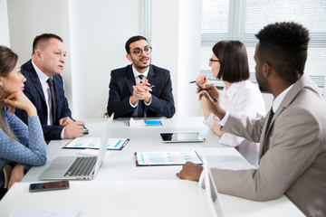 Multy-ethnic group of young business people working with computer at office