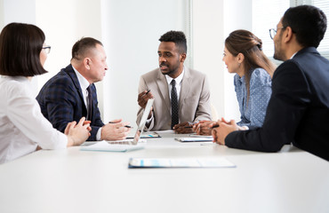 Multy-ethnic group of young business people working with computer at office