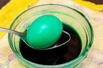 Painting, dying green eggs for Easter in glass jar
