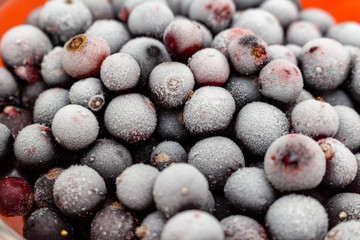 frozen black currant berries in a glass jar background