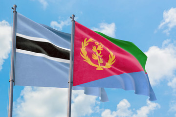 Fototapeta na wymiar Eritrea and Botswana flags waving in the wind against white cloudy blue sky together. Diplomacy concept, international relations.