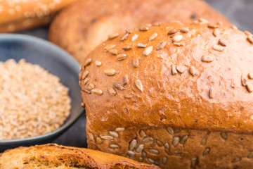 Different kinds of fresh baked bread on a black concrete background. side view, selective focus.