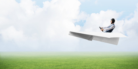 Naklejka na ściany i meble Happy aviator driving small paper plane