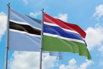 Gambia and Botswana flags waving in the wind against white cloudy blue sky together. Diplomacy concept, international relations.