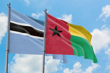 Guinea Bissau and Botswana flags waving in the wind against white cloudy blue sky together. Diplomacy concept, international relations.