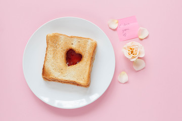 Toast with a heart jam on white plate and a valentine message. Valentine day concept 