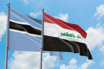 Iraq and Botswana flags waving in the wind against white cloudy blue sky together. Diplomacy concept, international relations.